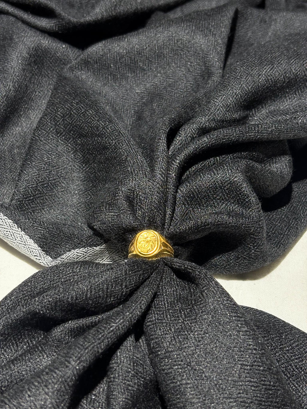 Gold ring on a knotted black fabric
