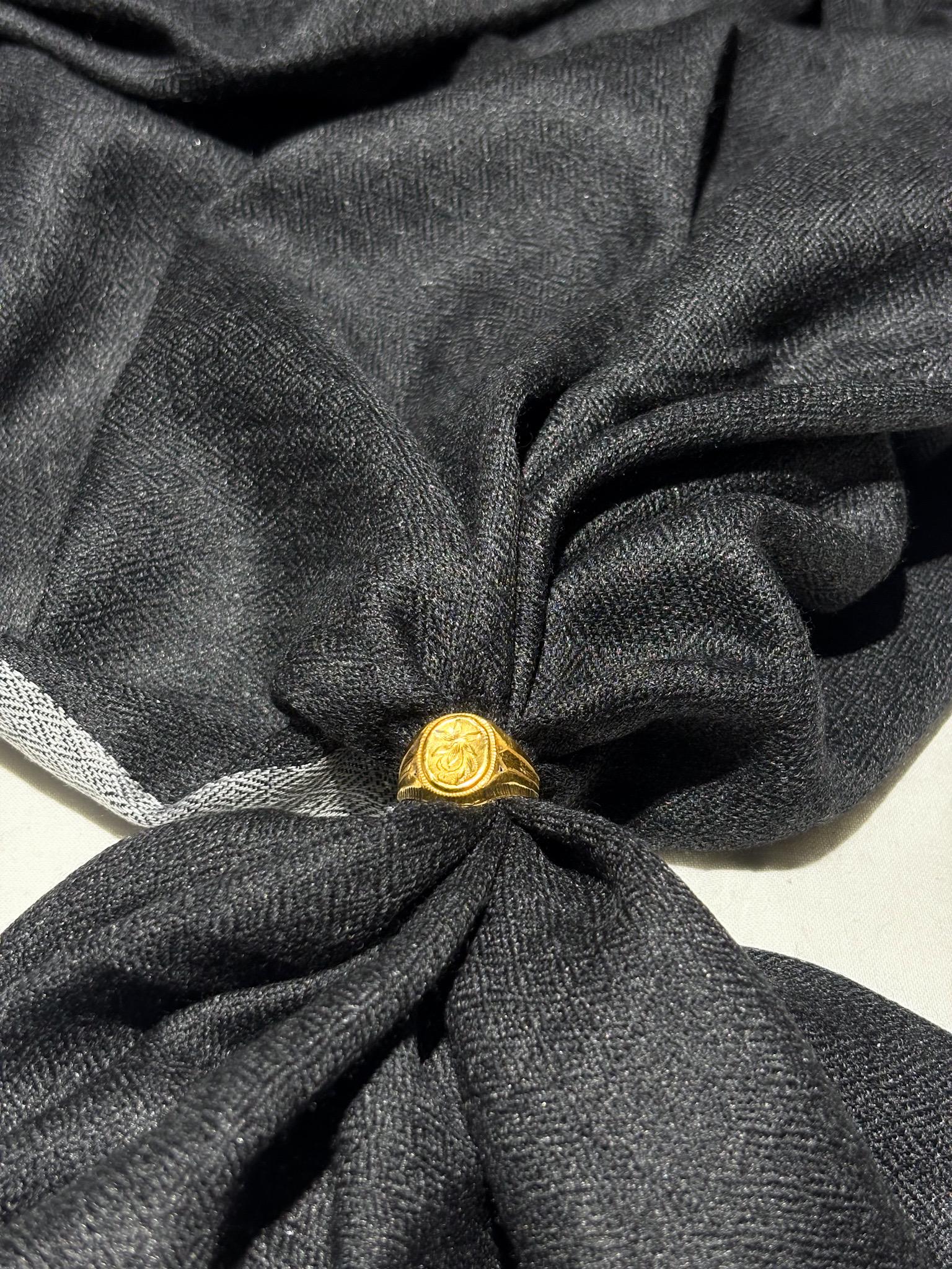 Gold ring on a knotted black fabric