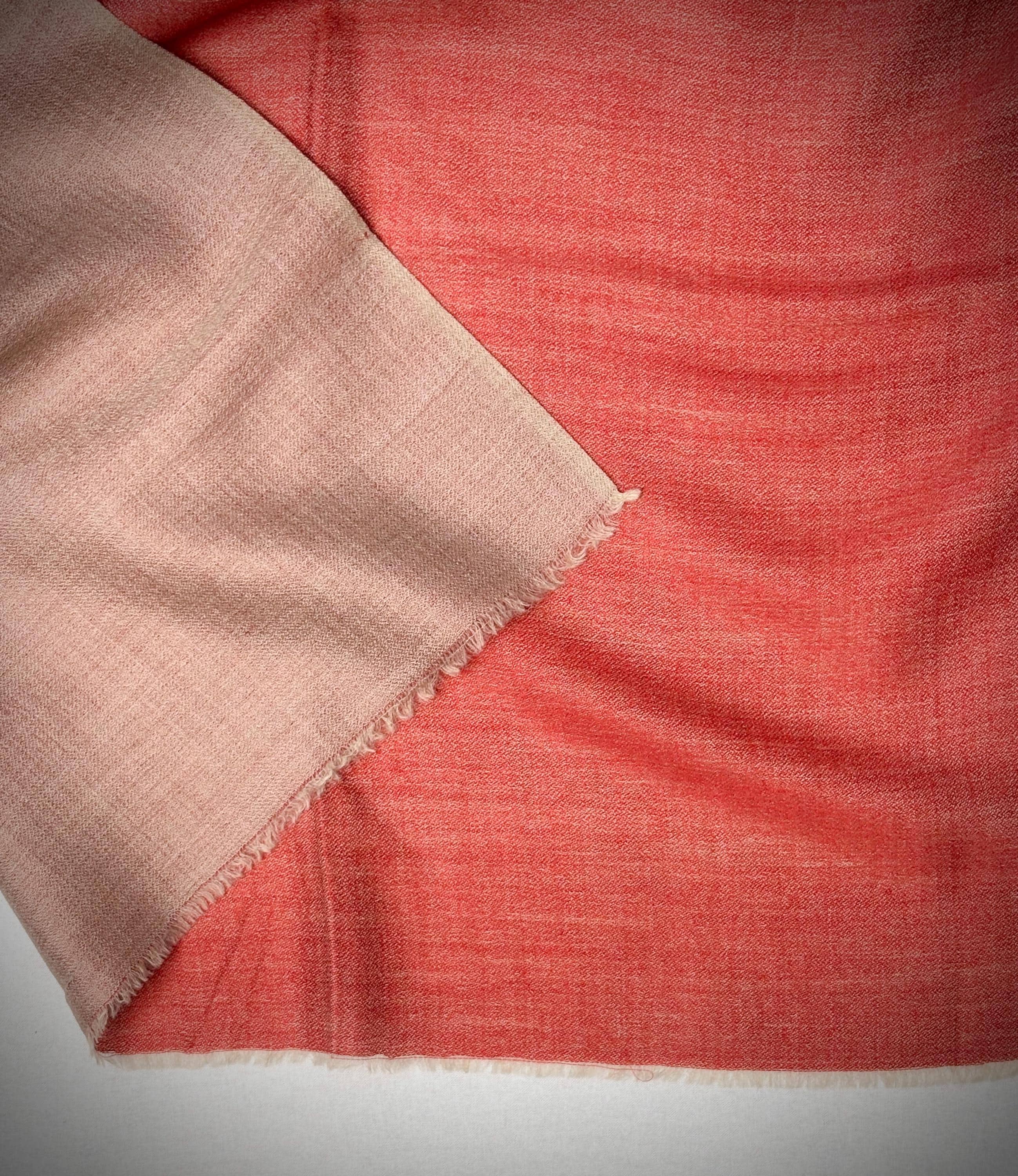 Close-up of two different fabric textures, one beige and one red, on a white background.