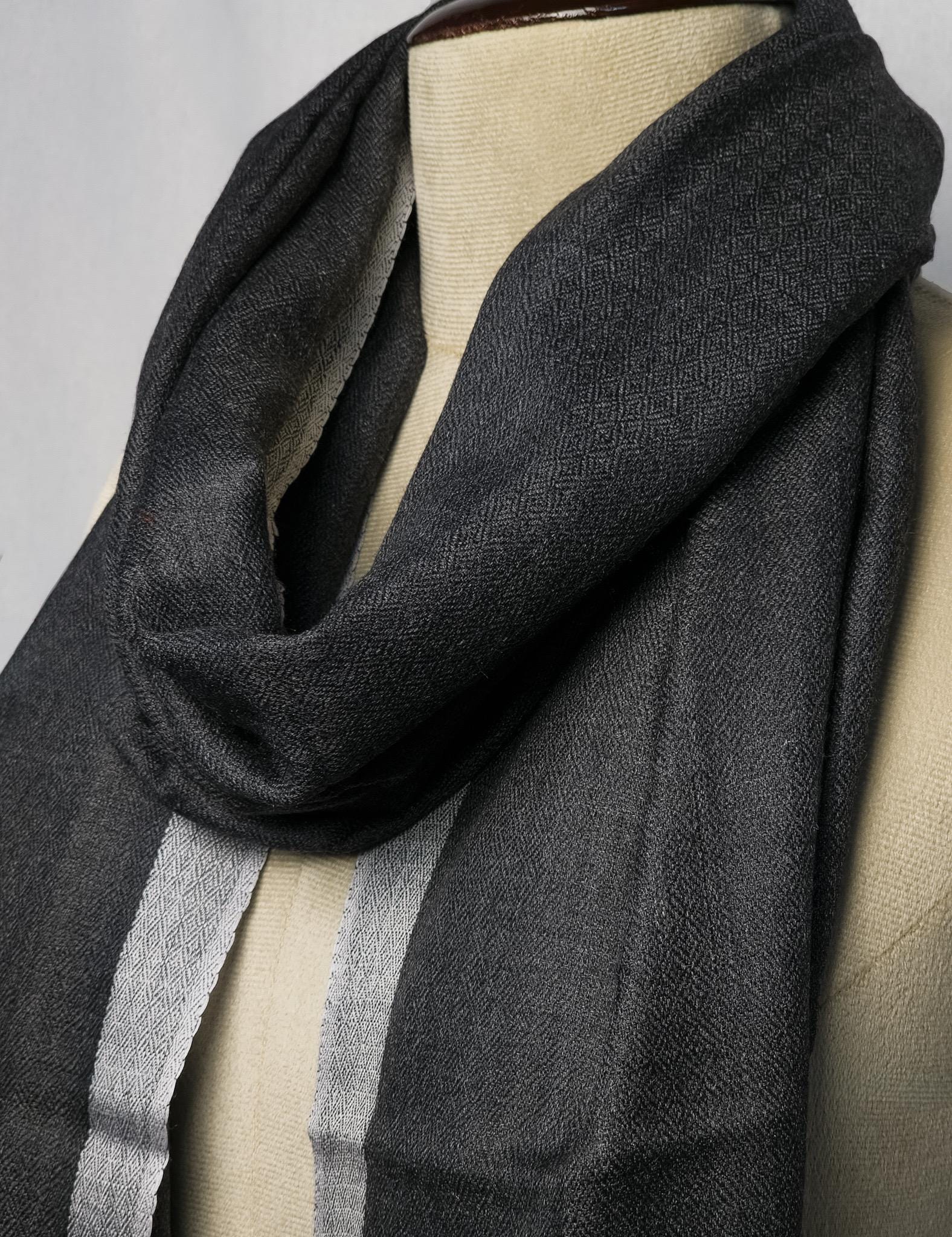 Gray scarf draped over a mannequin on a gray background