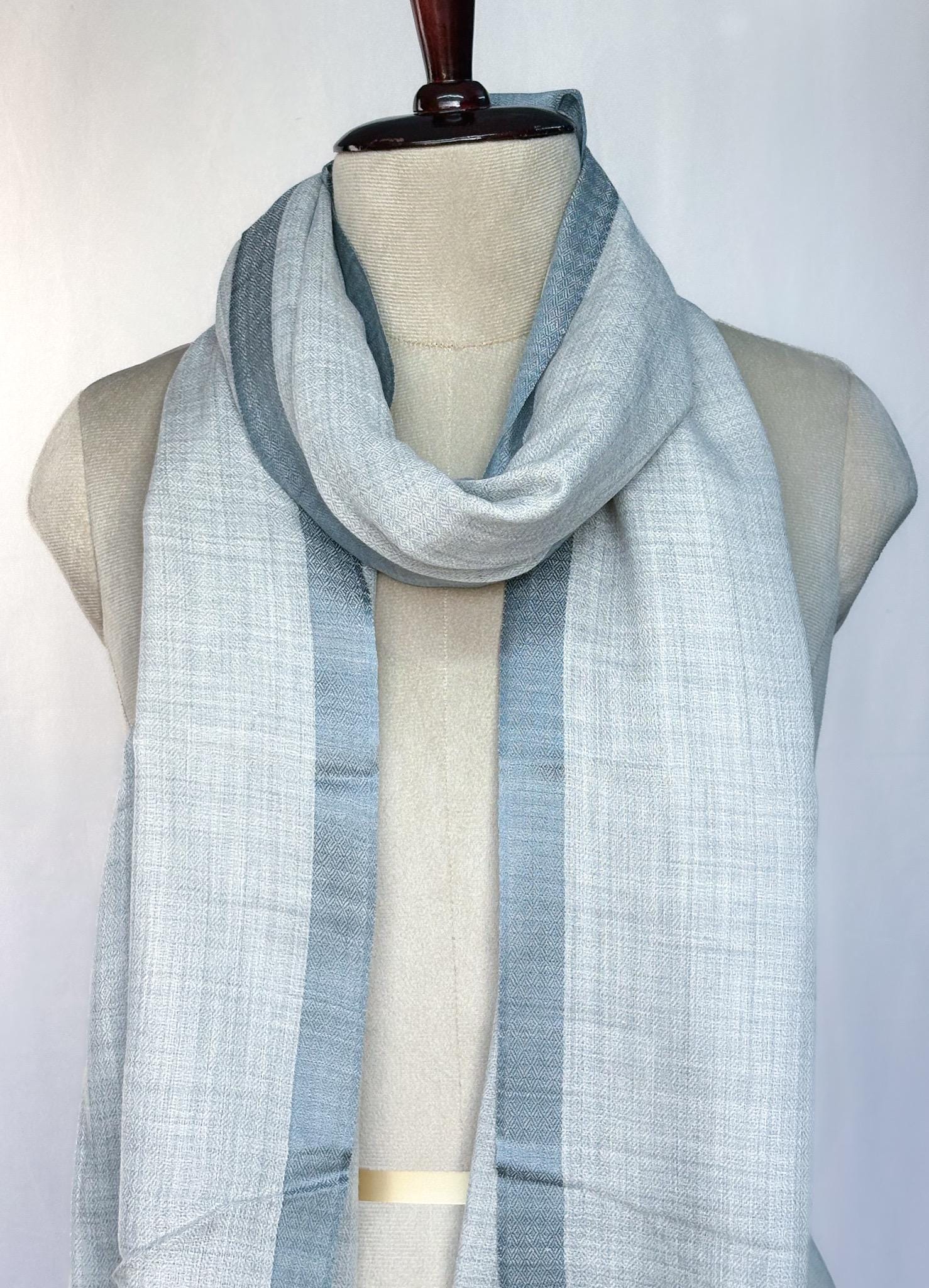 Light blue scarf draped over a mannequin on a white background