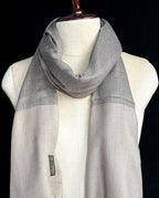 Gray scarf on a mannequin against a black background