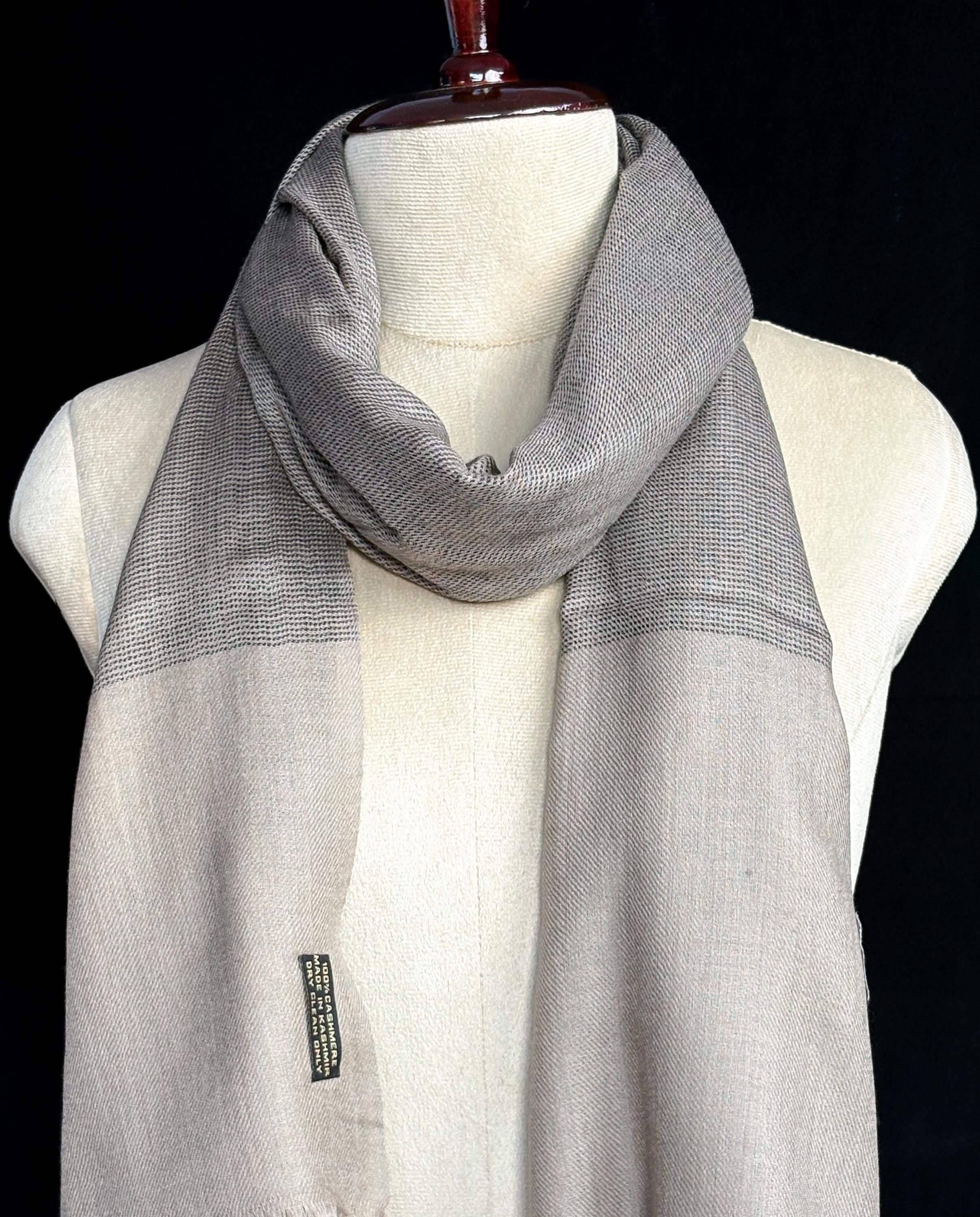 Gray scarf on a mannequin against a black background