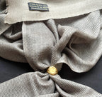 Close-up of a textured fabric with a gold button and a visible brand label.