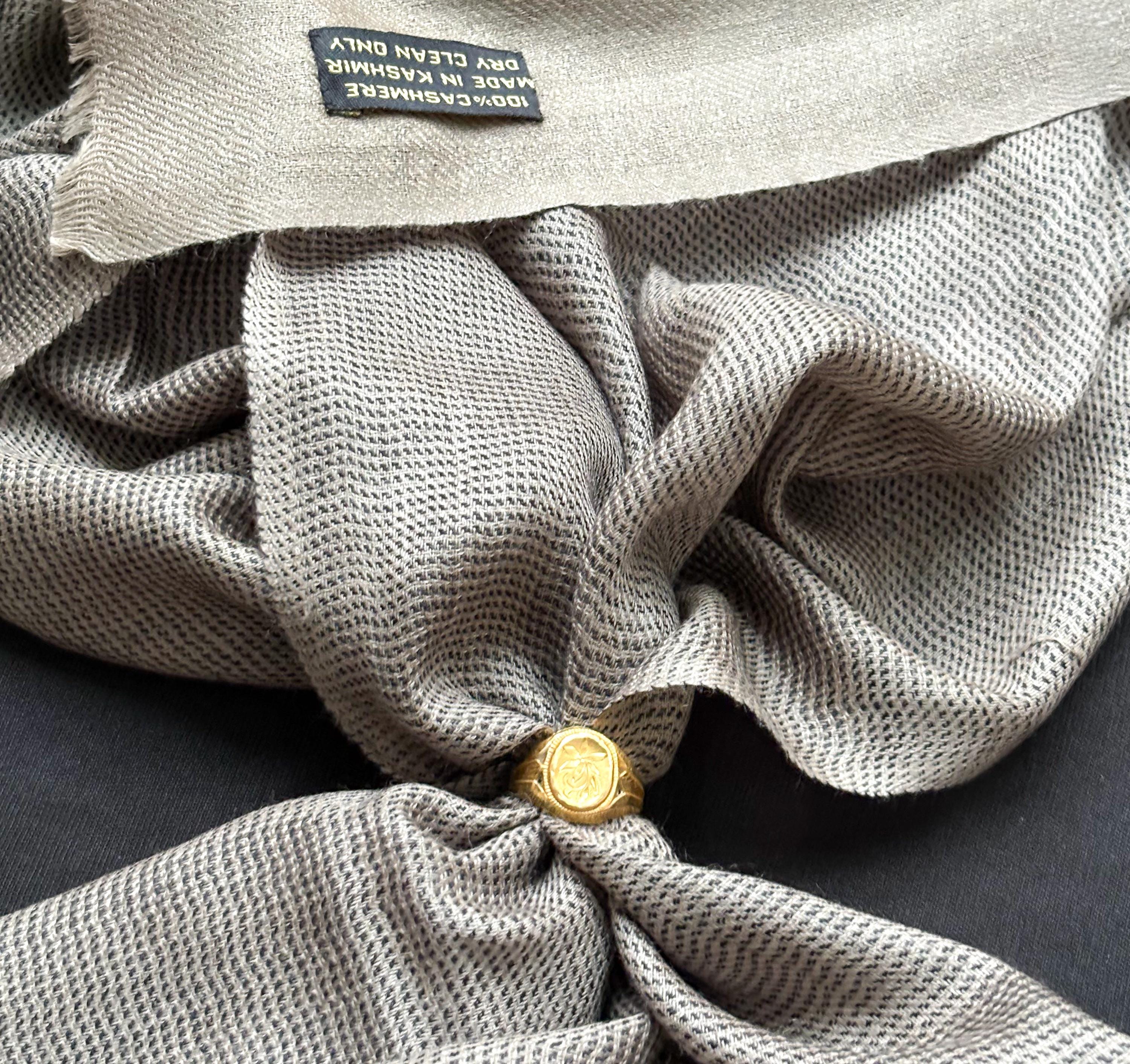 Close-up of a textured fabric with a gold button and a visible brand label.