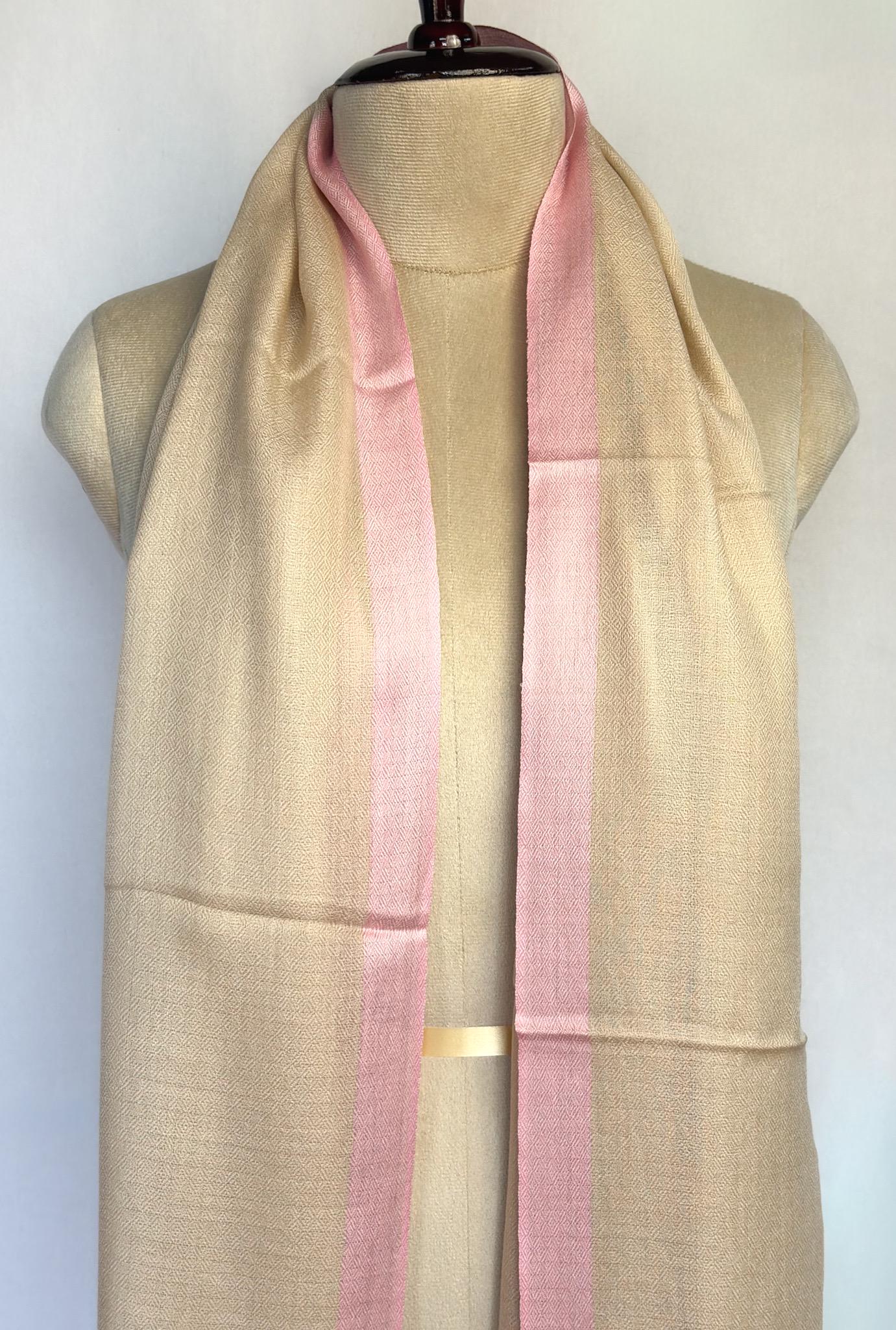 Beige and pink scarf on a mannequin with a plain background