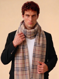 Man wearing a plaid scarf against a beige background