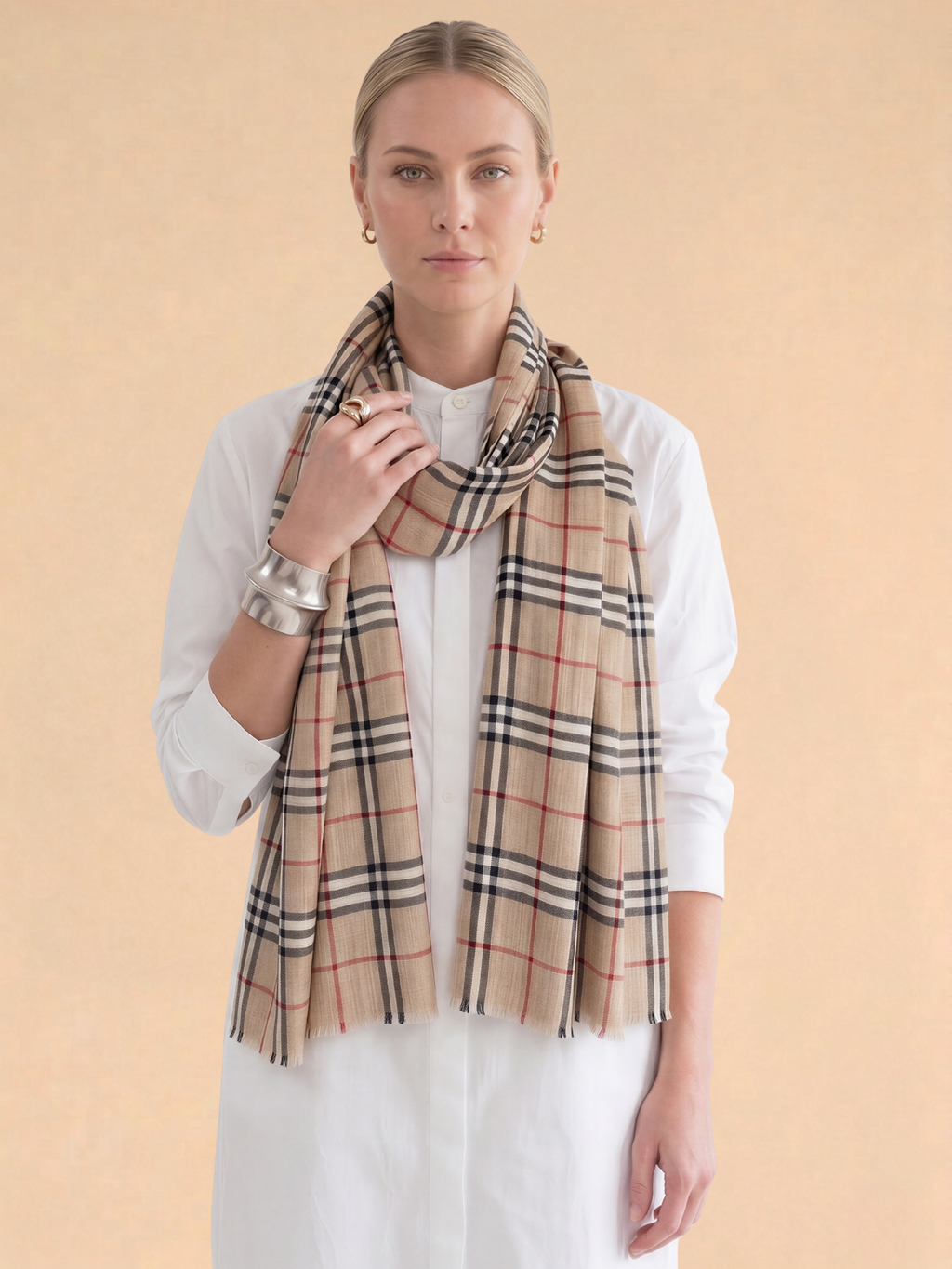 Woman wearing a plaid scarf on a beige background