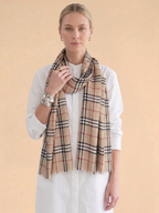 Woman wearing a plaid scarf on a beige background