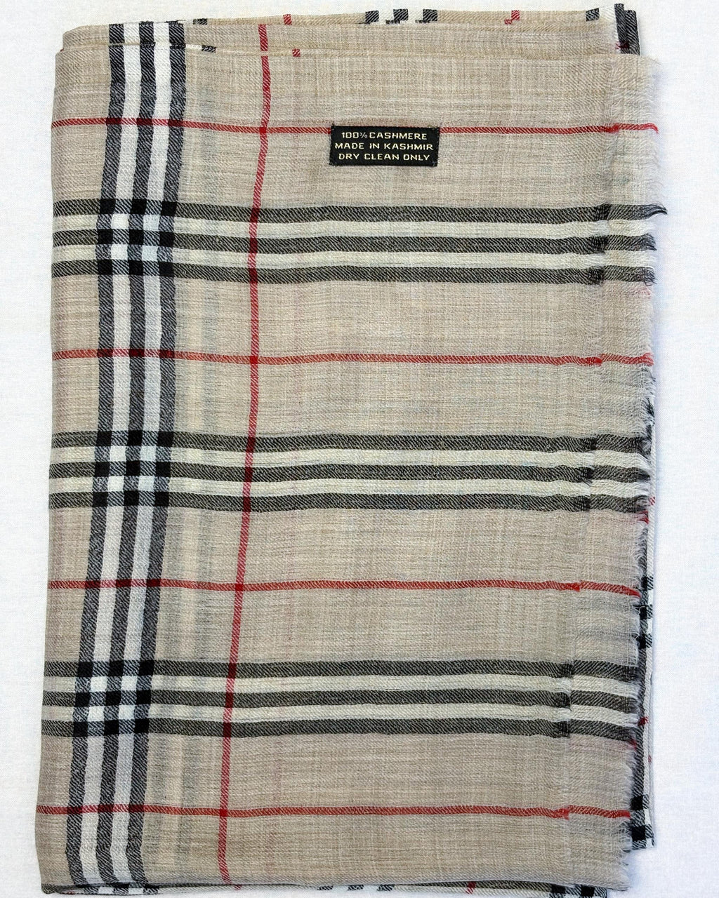 Plaid fabric with red, black, and white lines on a beige background