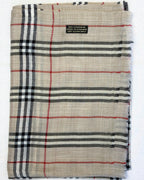 Plaid fabric with red, black, and white lines on a beige background