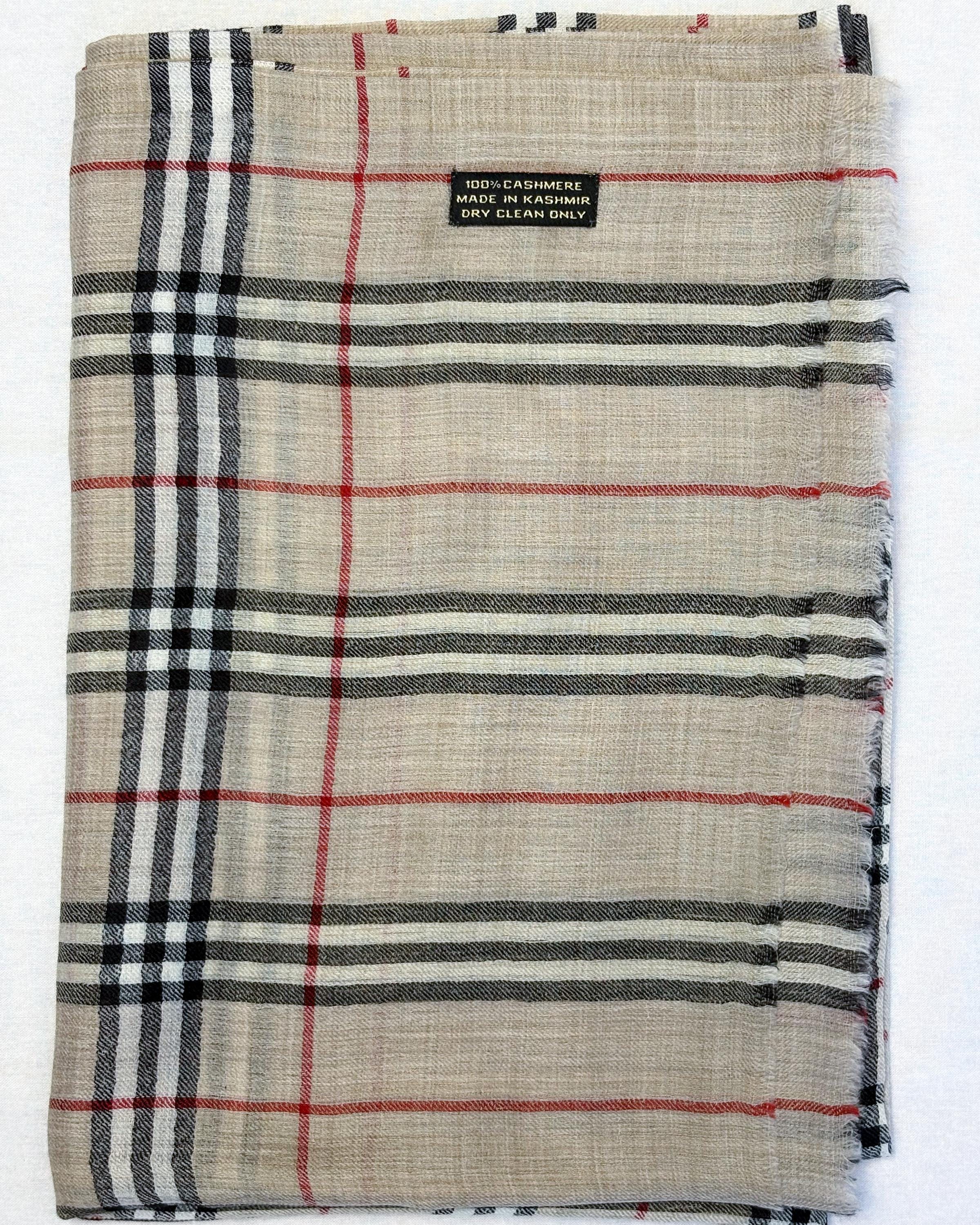 Plaid fabric with red, black, and white lines on a beige background