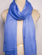 Blue scarf draped over a mannequin on a plain background