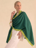 Woman wearing a green and yellow shawl against a beige background