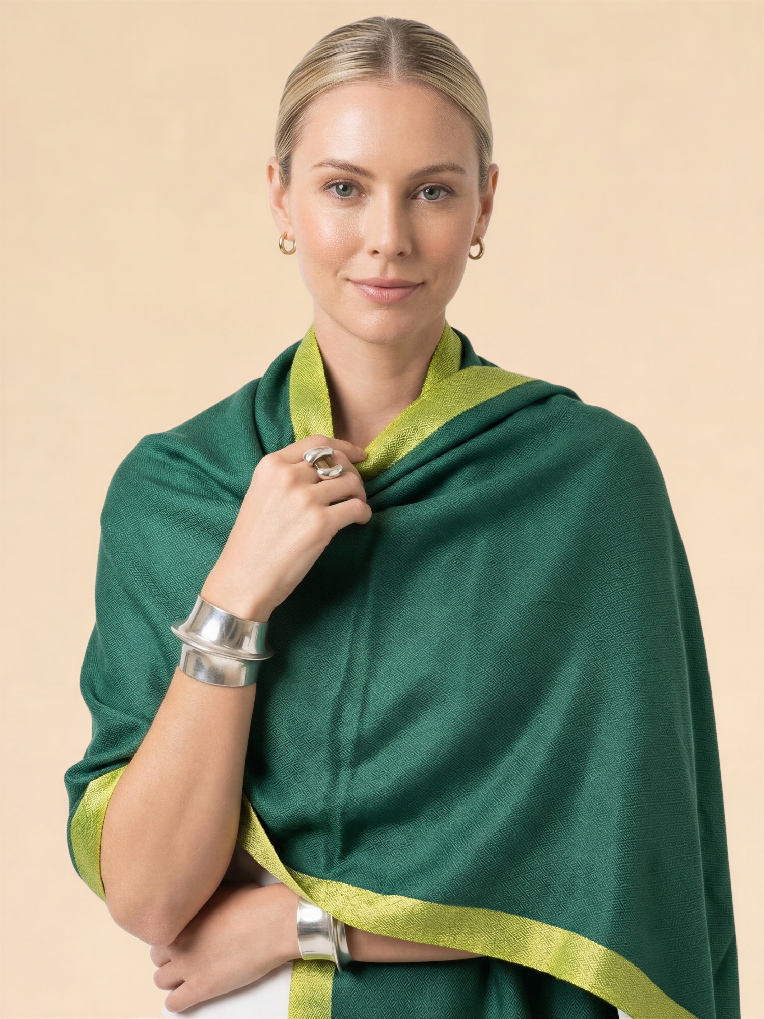 Woman wearing a green shawl with yellow trim on a beige background