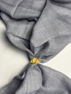 Gray fabric with a gold tie knot on a light background