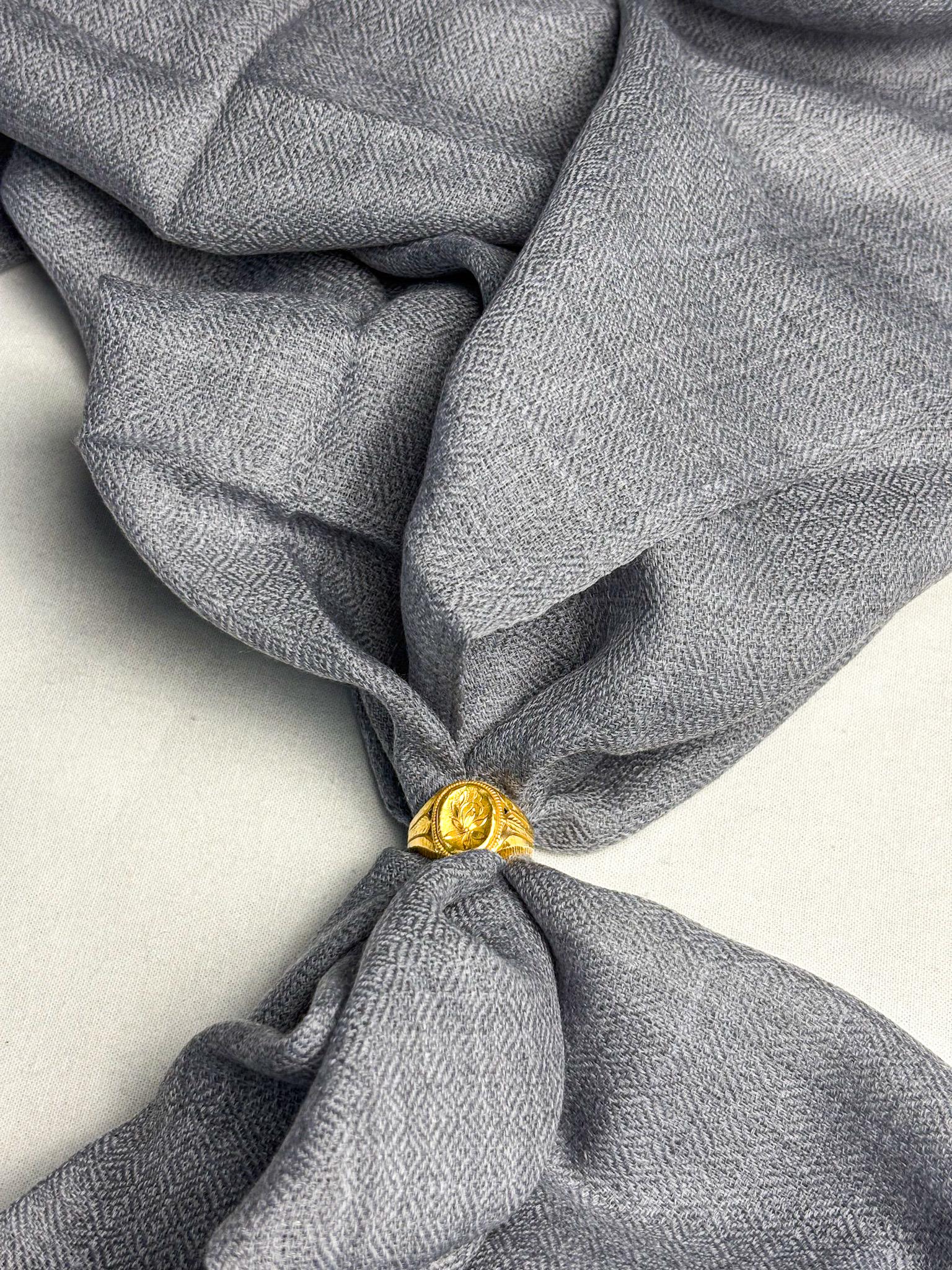 Gray fabric with a gold tie knot on a light background