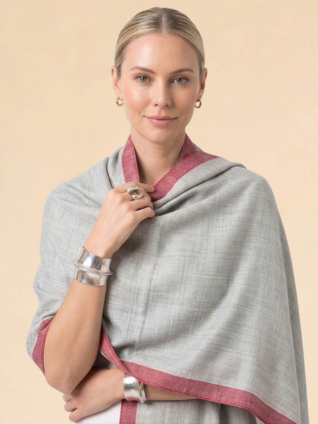 Woman wearing a gray and red scarf on a beige background