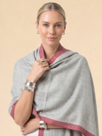 Woman wearing a gray and red scarf on a beige background