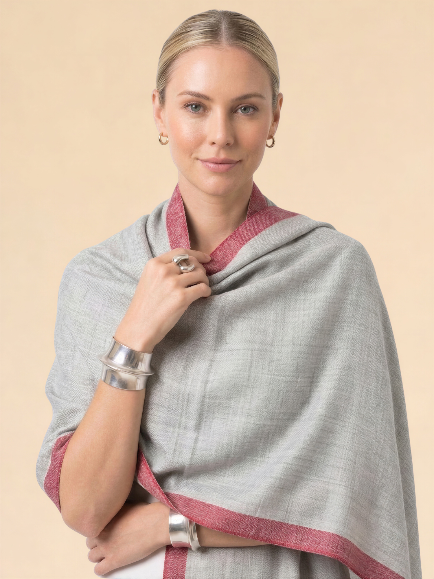 Woman wearing a gray and red scarf on a beige background