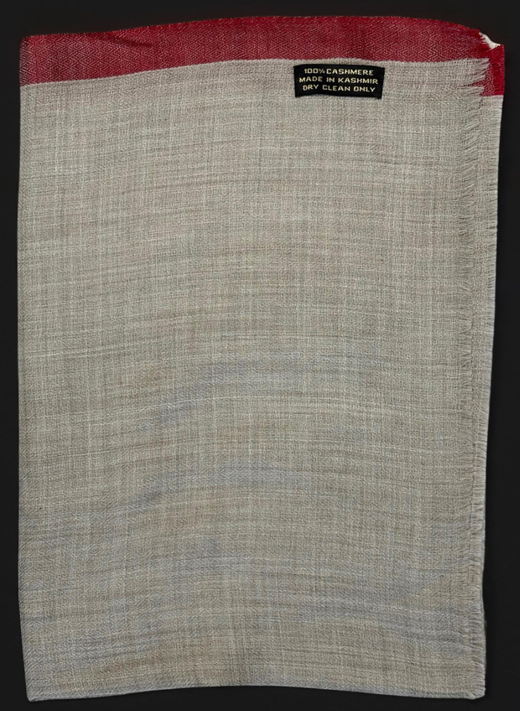 Gray fabric with red border and 'Dry Clean Only' label on a black background