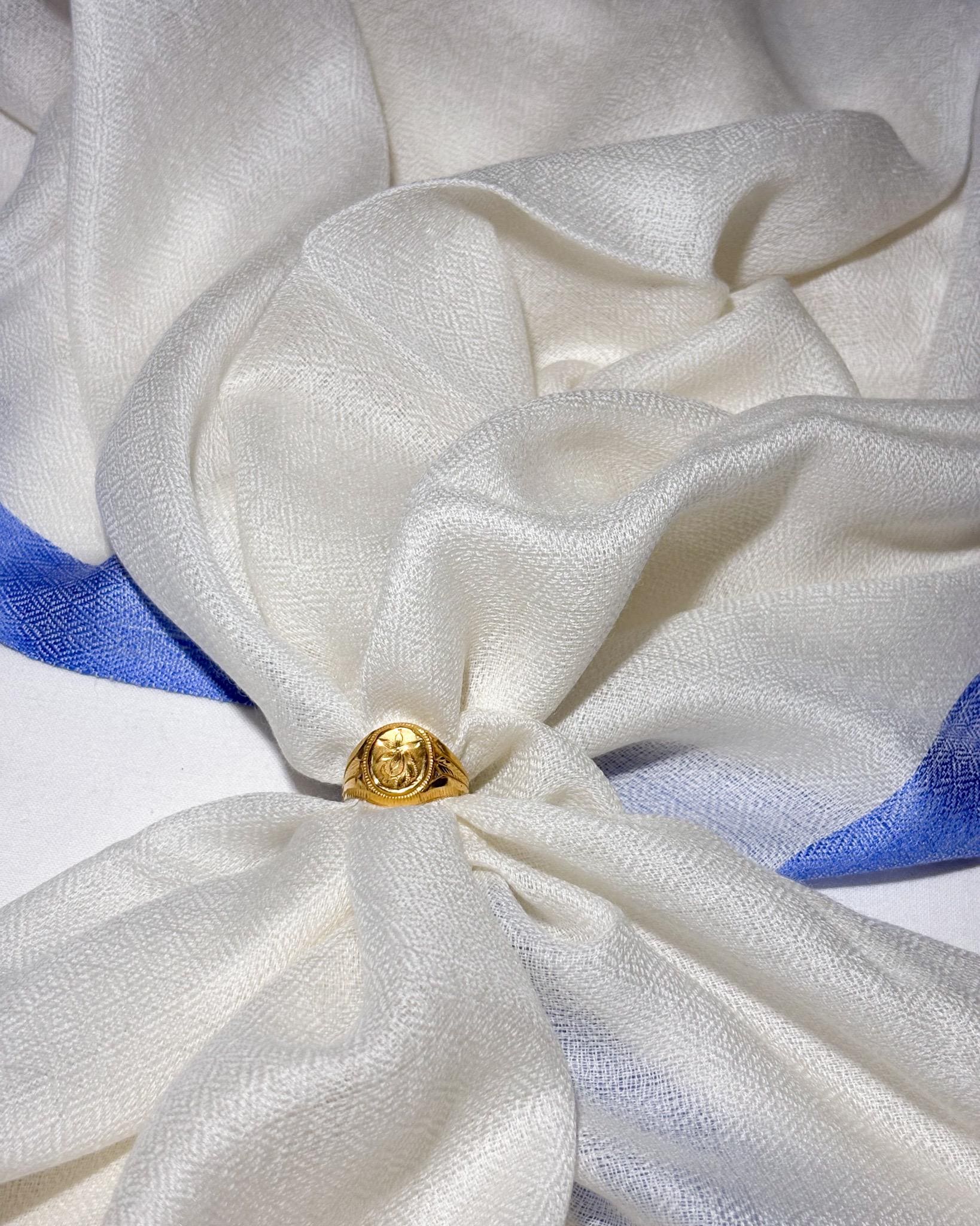 Gold ring on a white fabric with blue ribbon