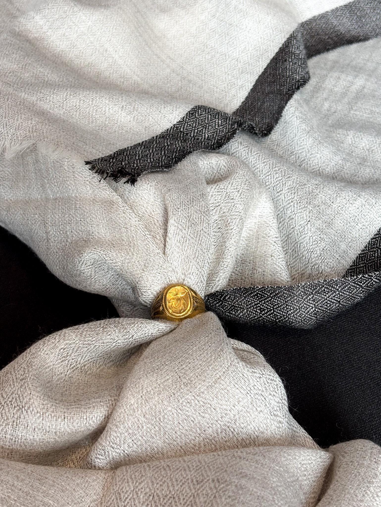 Close-up of a textured fabric with a gold button on a black background