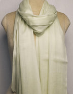 Light green scarf draped over a mannequin on a plain background