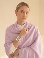 Woman wearing a light purple scarf with a plain background
