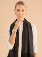 Woman wearing a dark scarf on a beige background