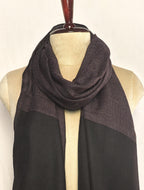 Black and brown patterned scarf on a mannequin against a white background