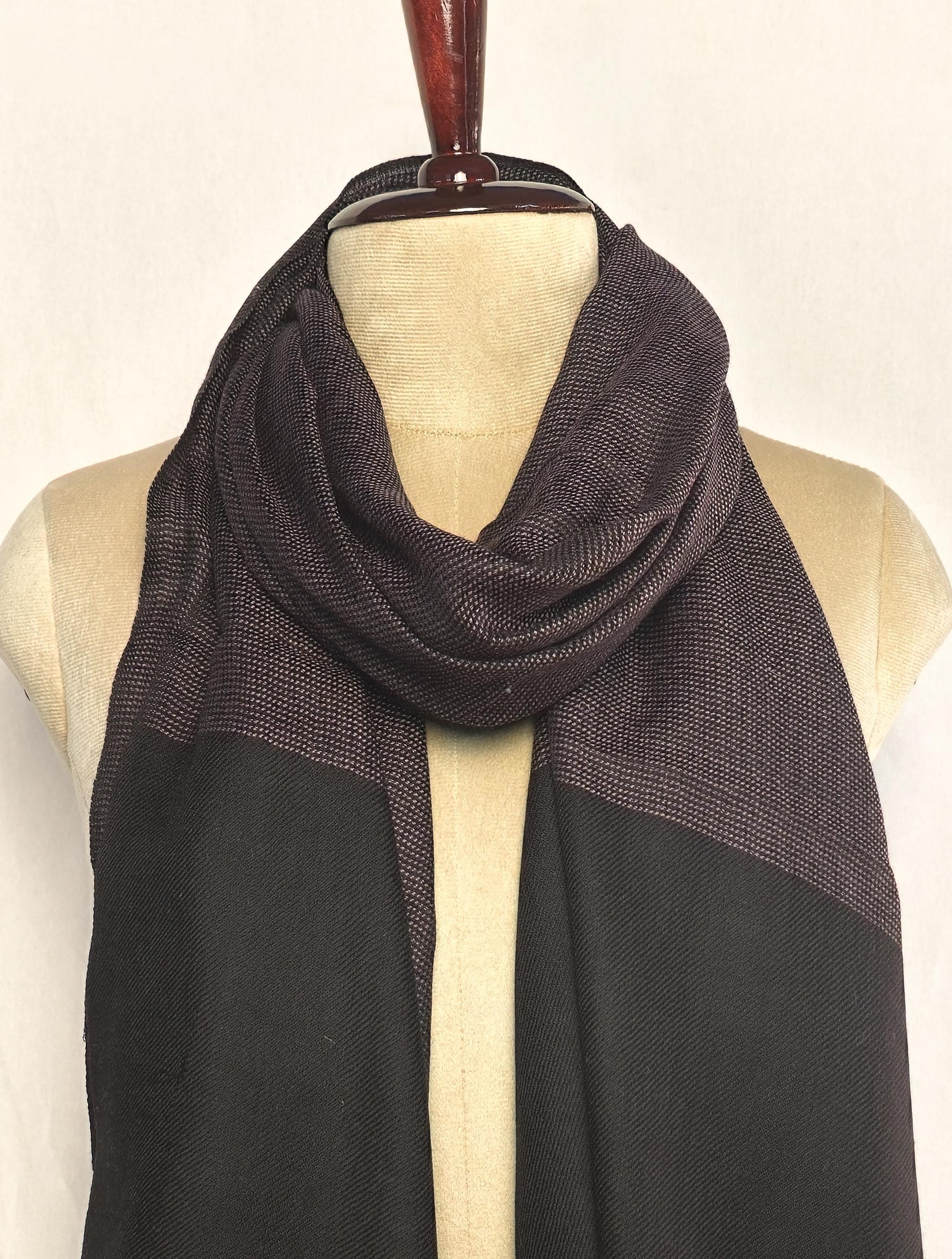 Black and brown patterned scarf on a mannequin against a white background