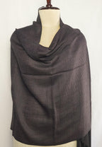 Dark gray scarf draped over a mannequin against a white background