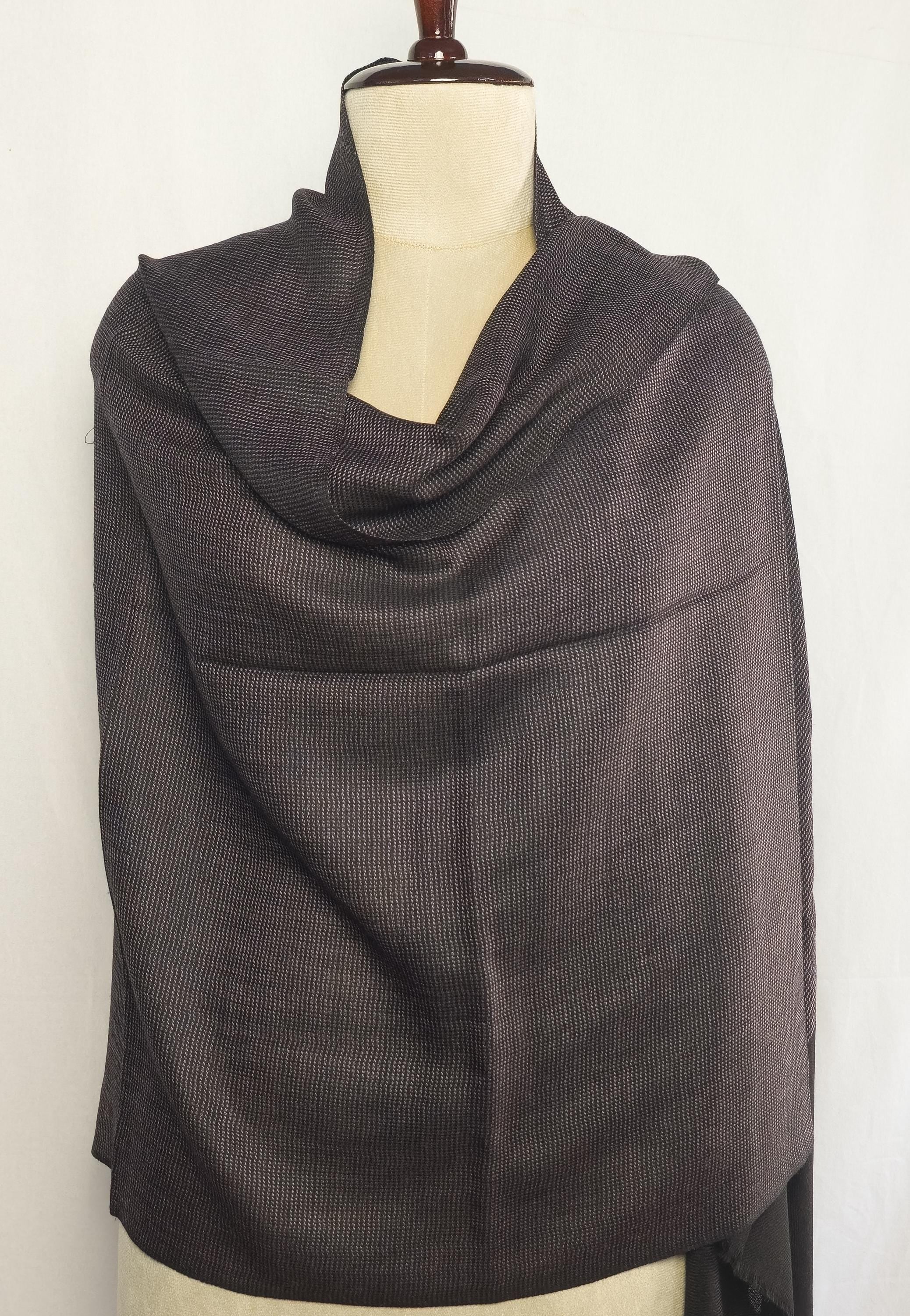 Dark gray scarf draped over a mannequin against a white background
