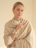 Woman wearing a beige scarf with a plain background