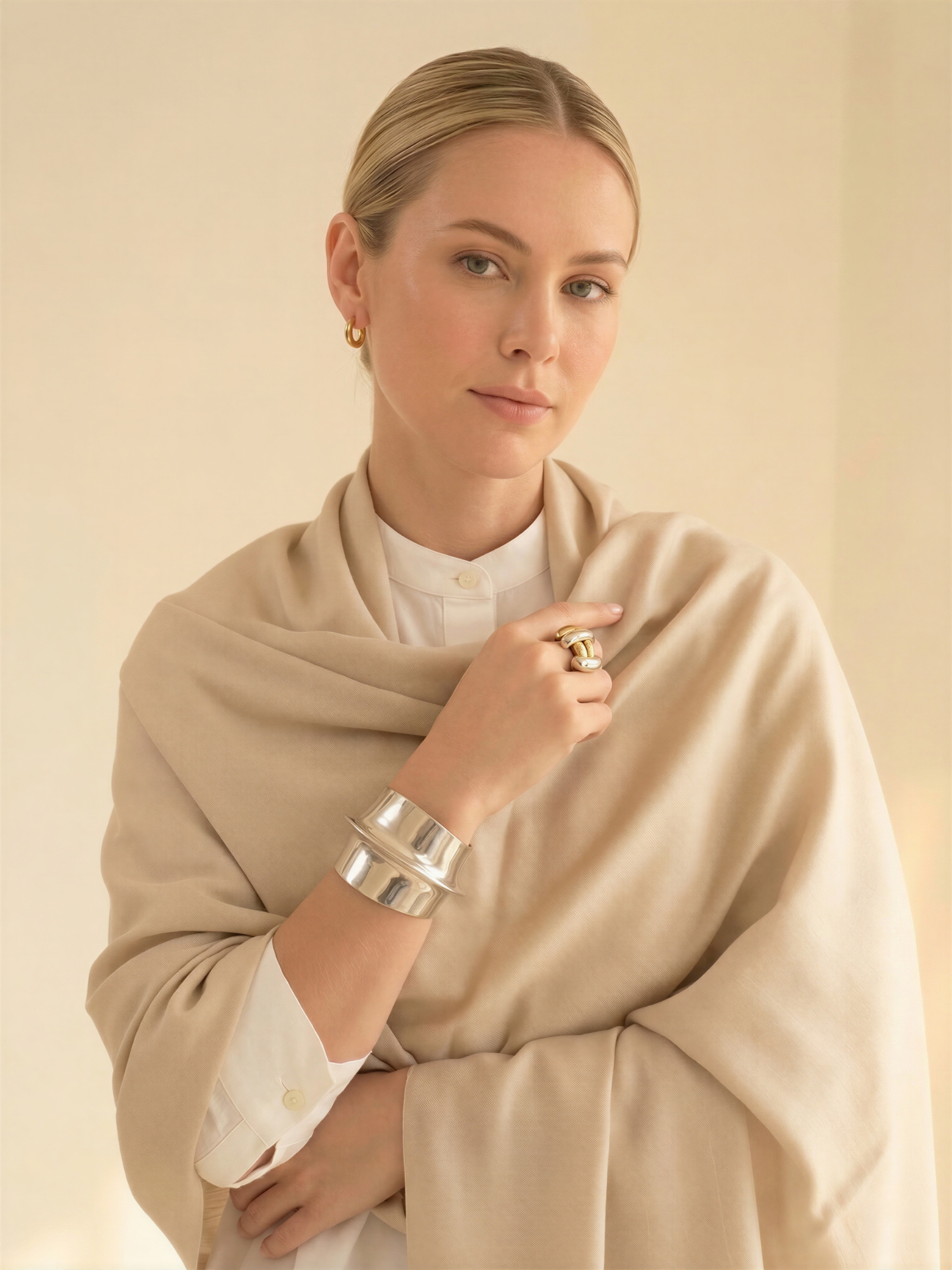 Woman wearing a beige scarf with a plain background