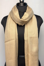 Beige scarf draped over a black mannequin against a white background