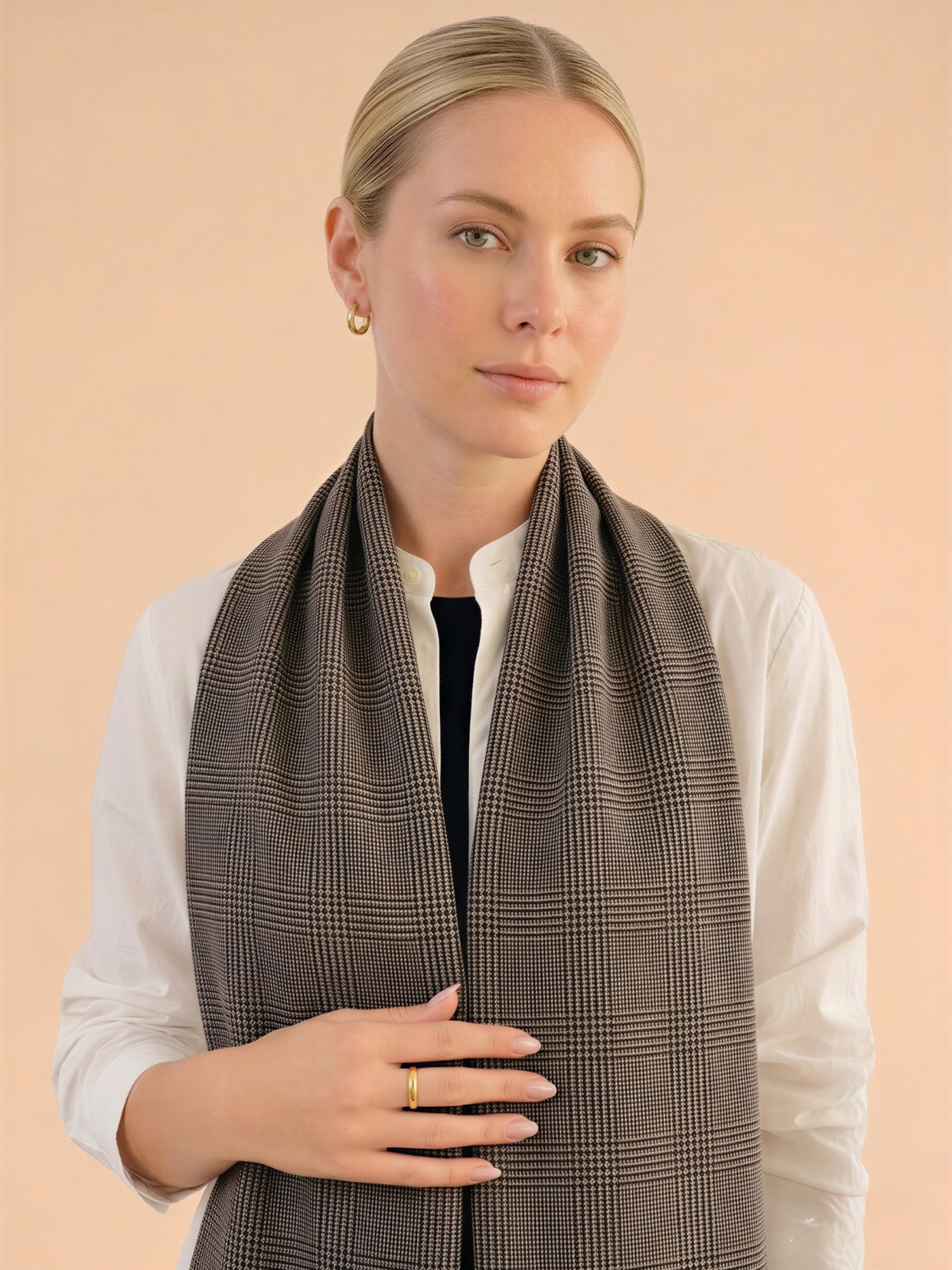 Woman wearing a brown checkered scarf against a beige background