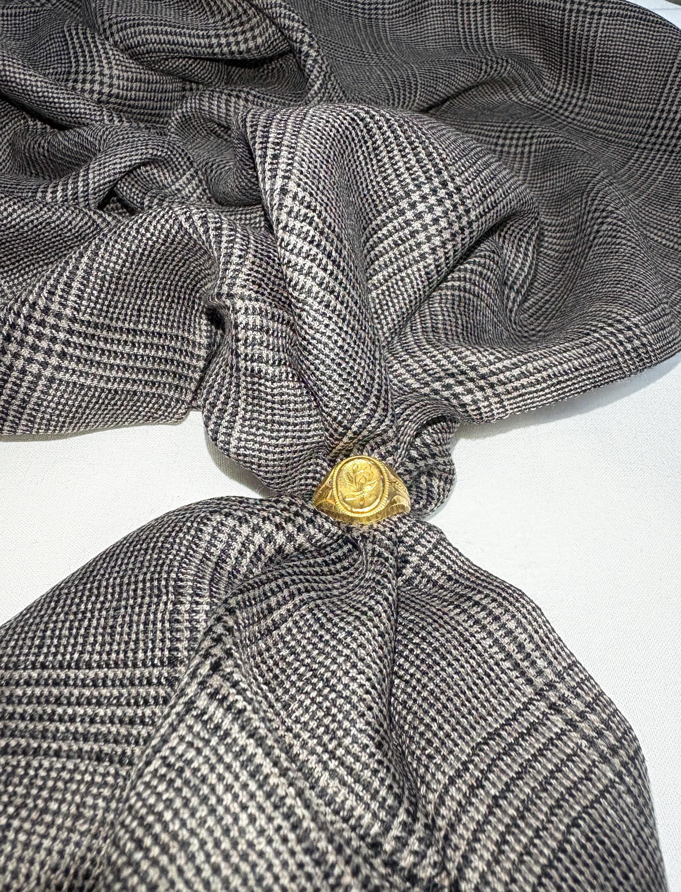 Gray checkered fabric with a gold button on a white background
