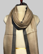 Beige scarf with black accents draped over a mannequin on a plain background