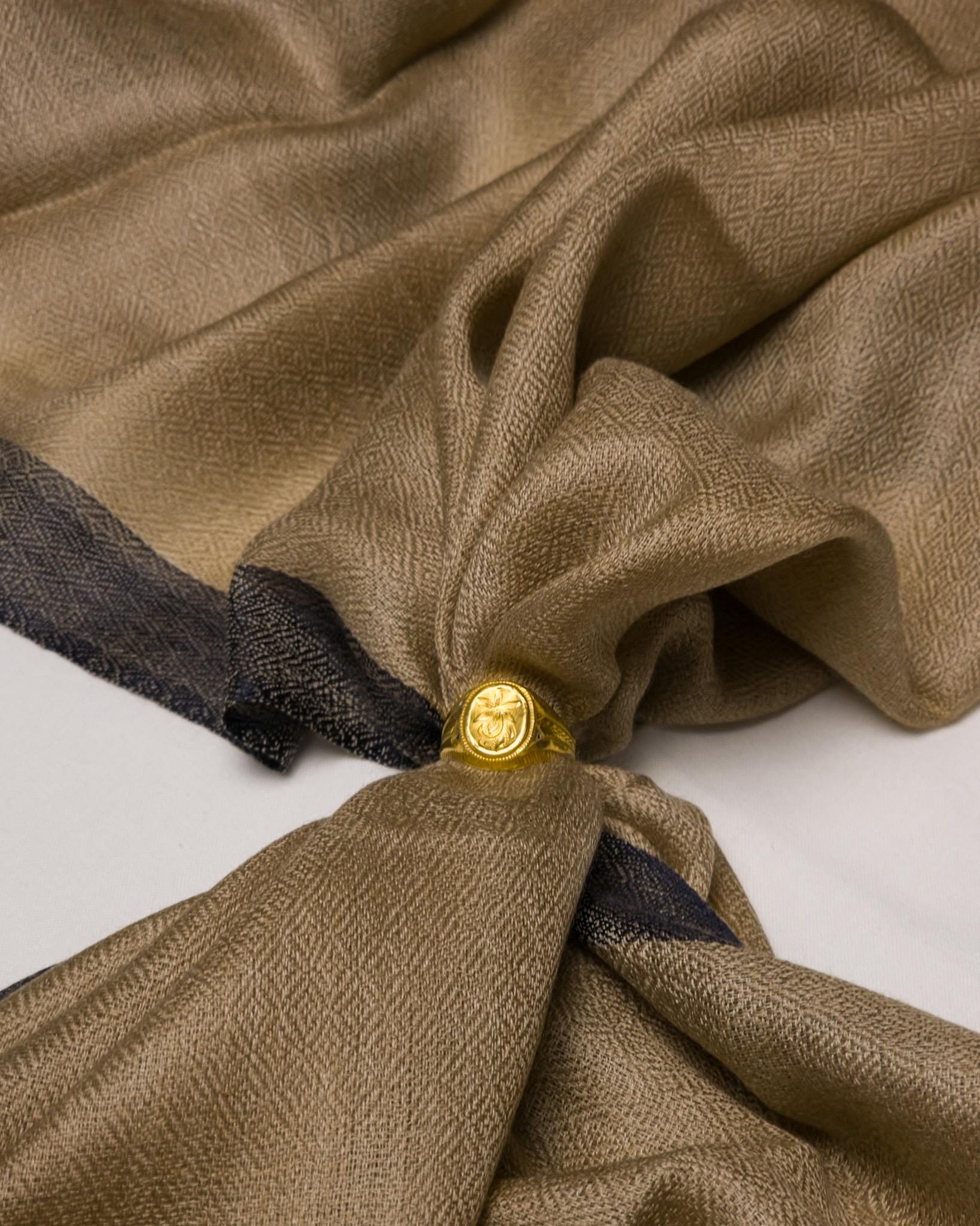 Close-up of a brown fabric with a gold button on a white background