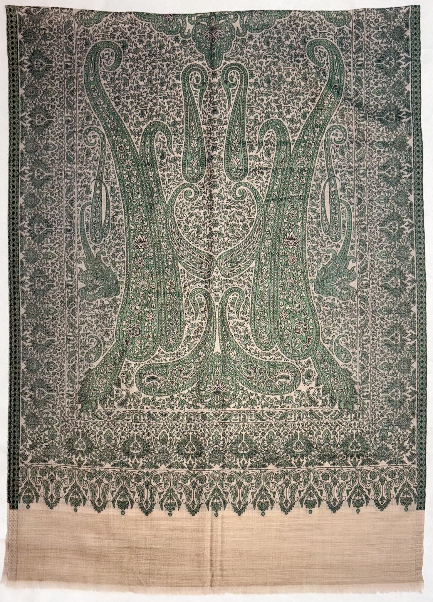 Decorative fabric with intricate green and beige pattern on a plain background
