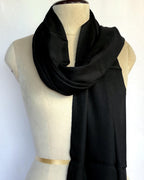 Black scarf draped over a mannequin on a white background