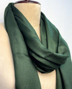 Green scarf draped over a mannequin on a white background