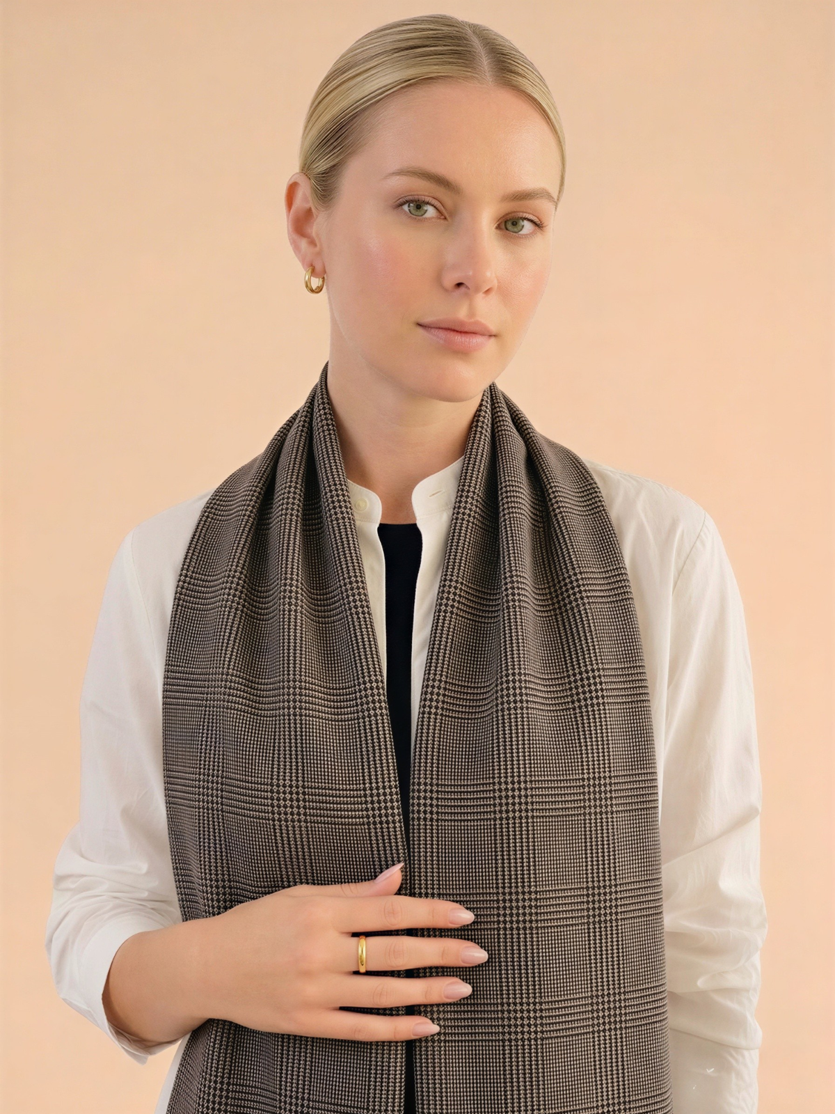 Woman wearing a brown checkered Kashmiri wool scarf against a beige background